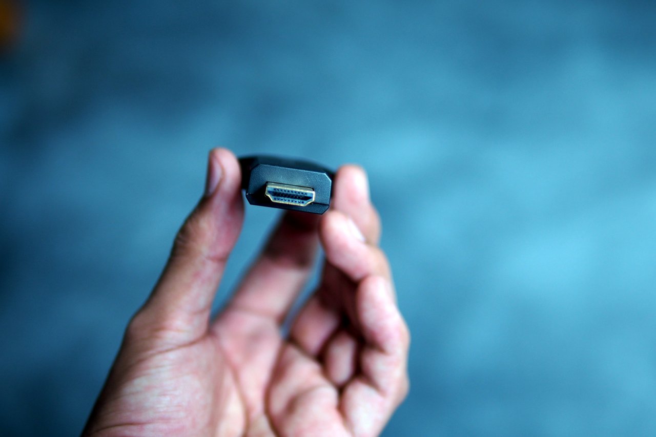 First-generation Chromecast HDMI dongle held in a hand
